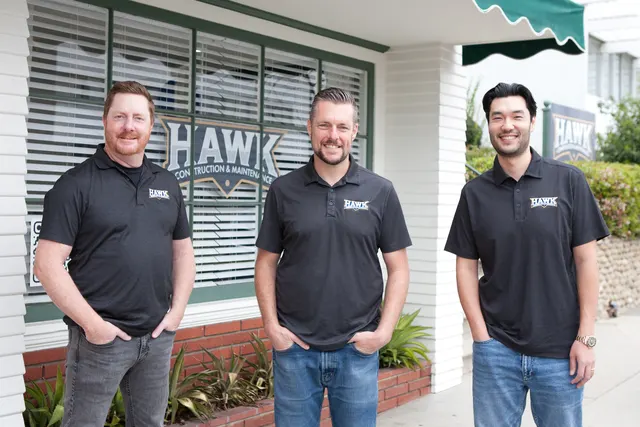 Three members of the Hawk Construction team outside the Hawk office